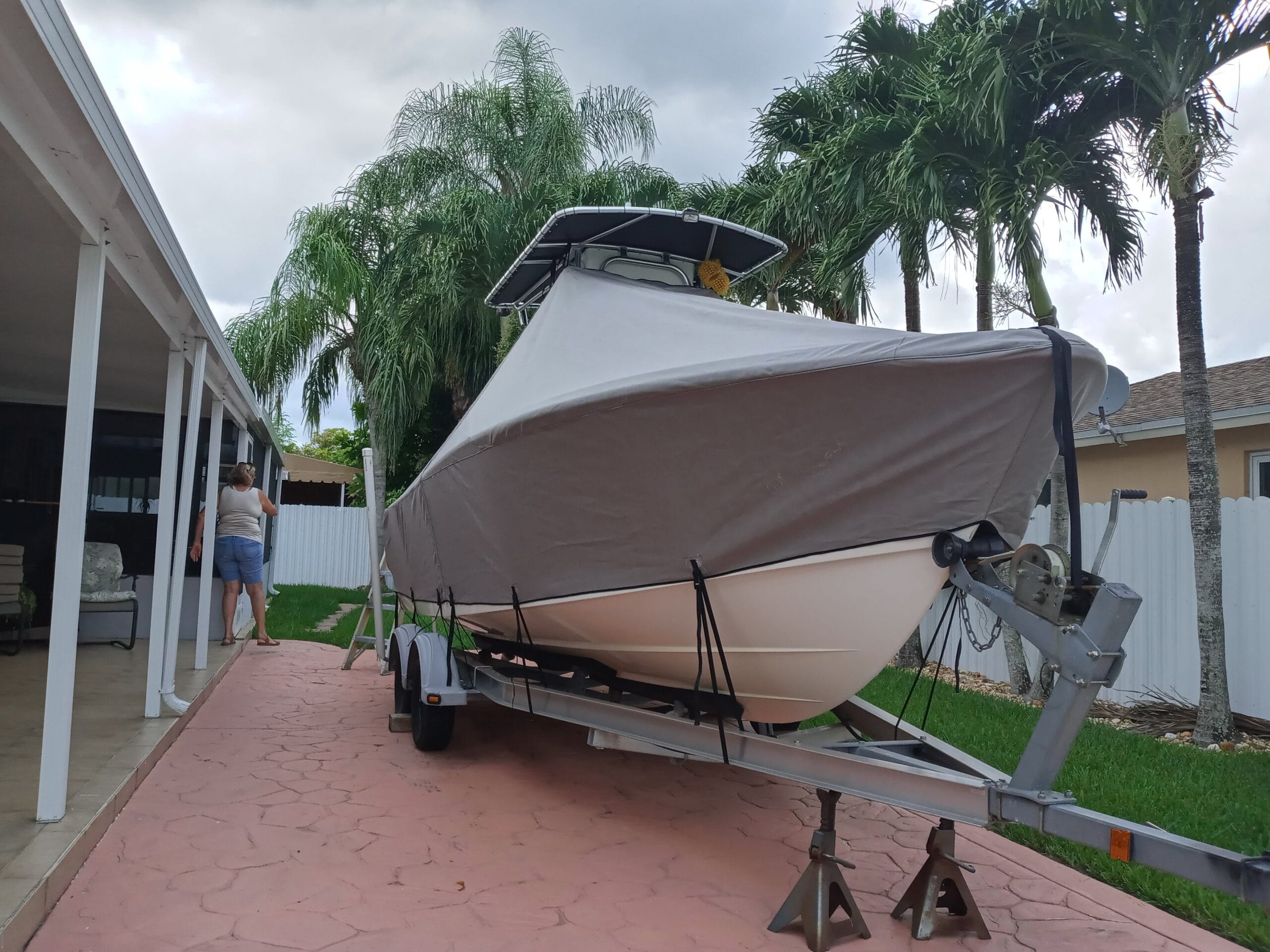 t-top fishing boat in Miami's residential house protect with a grey full boat cover 